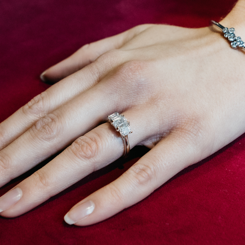 Person wearing an emerald cut diamond engagement ring