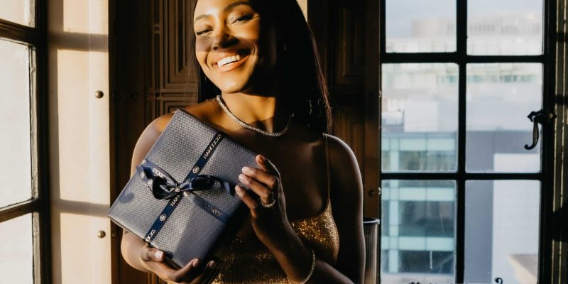 Young lady holding a gift box tied up with a bow